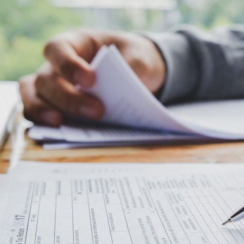 Man filling out tax paperwork, income is assessed for mortgages.