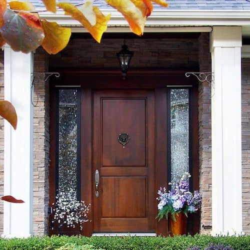 The front door of a suburban home with flowers, showcasing curb appeal and home aesthetics.