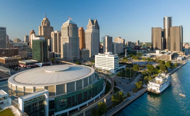A view of the Detroit skyline and a river boat along the shoreline.