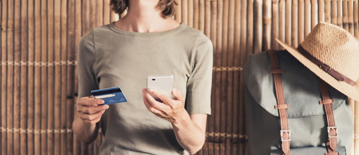 Woman holding a credit card and a cell phone.