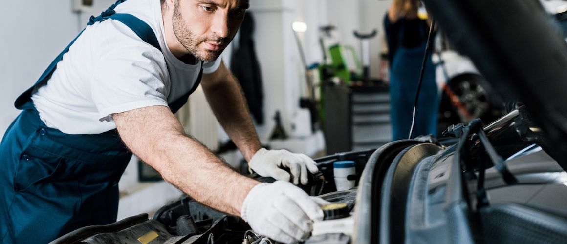 Image of worker repairing car engine.