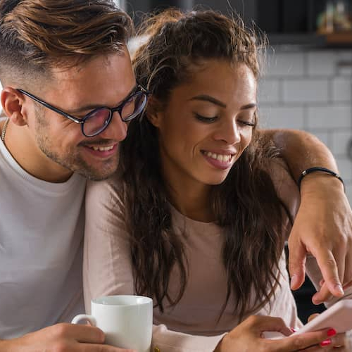 Couple searching rental listings together on a phone.