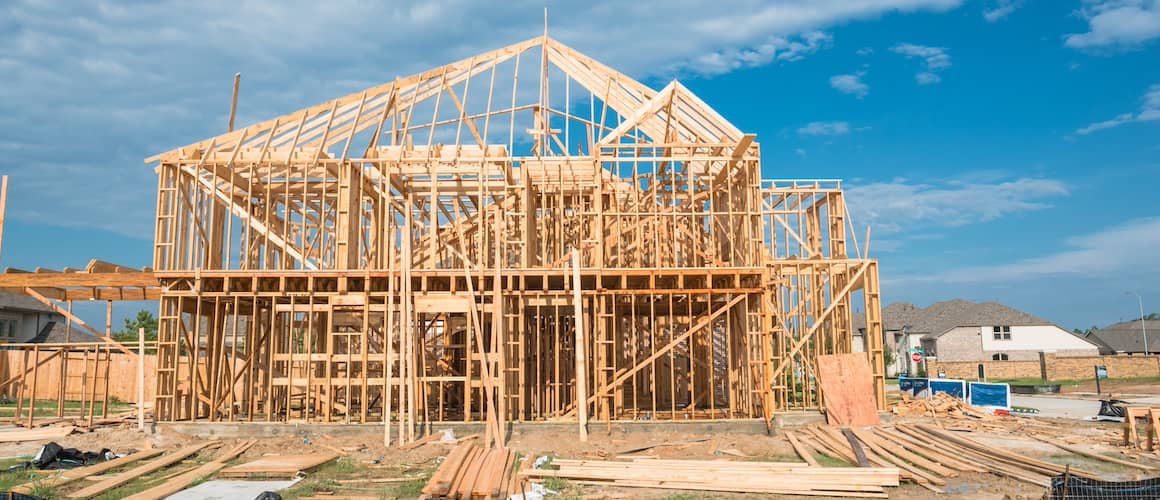 New stick built home under construction and blue sky in US