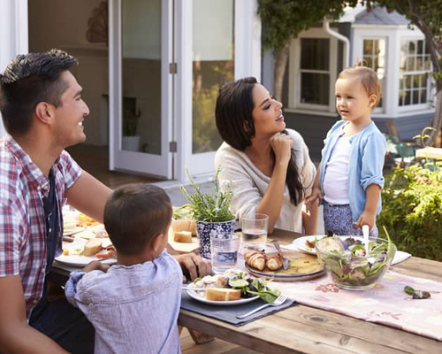 A family having a meal in their backyard.