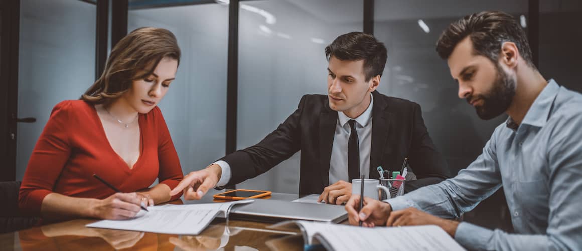 Lawyer helping a couple with paperwork.