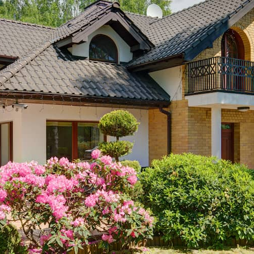 A house adorned with flowers, portraying a picturesque residential setting or curb appeal.