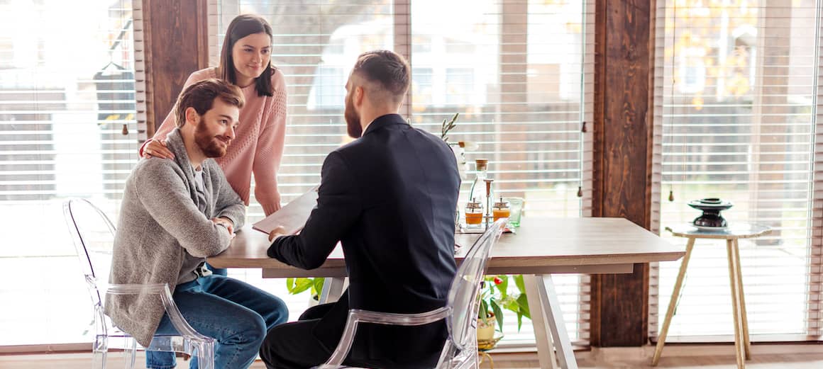 An image of a realtor suggesting a home improvement loan or financial aspect related to property renovation for a couple.