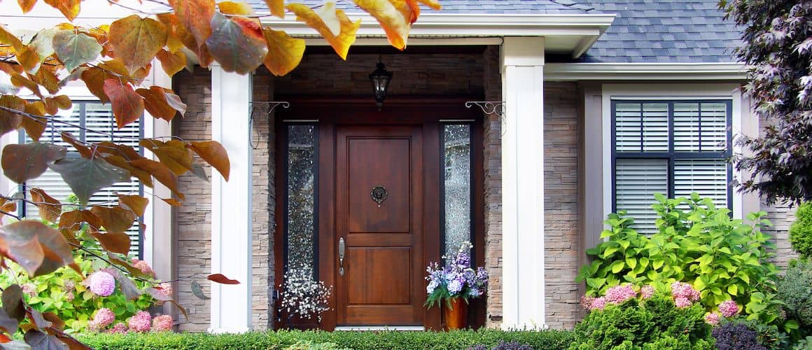 The front door of a suburban home with flowers, showcasing curb appeal and home aesthetics.