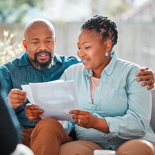 Couple holding documents and discussing.