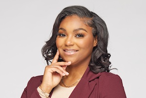 Headshot of a woman smiling at the camera against a neutral background.