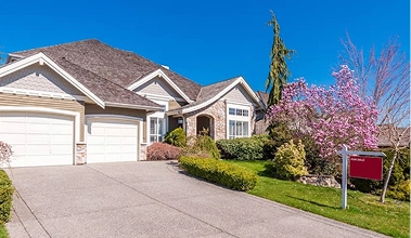Beautiful front view of home with a manicured lawn and for sale sign