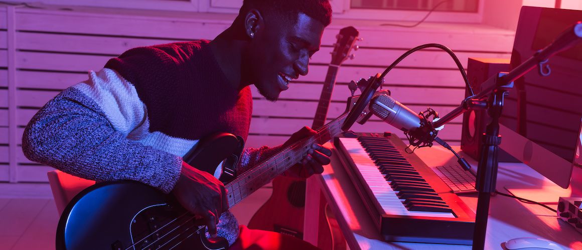 Image of man recording music in home studio.