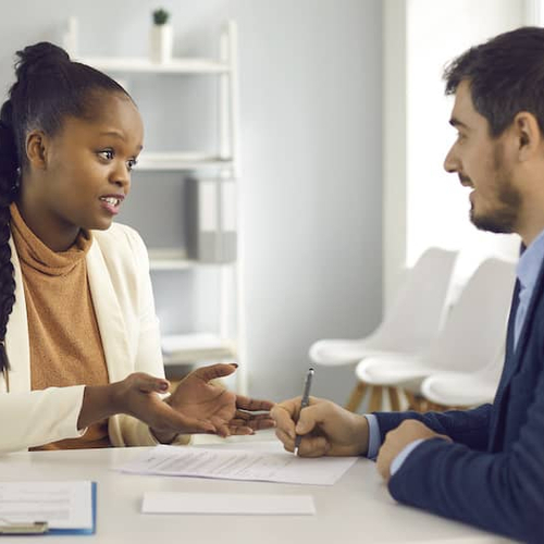 A man speaking to a financial advisor, potentially discussing financial planning related to real estate or homeownership.
