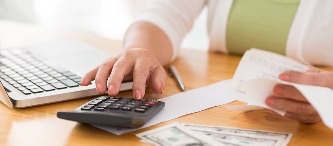 RHB Assets From IGX: A middle-aged woman using a calculator.