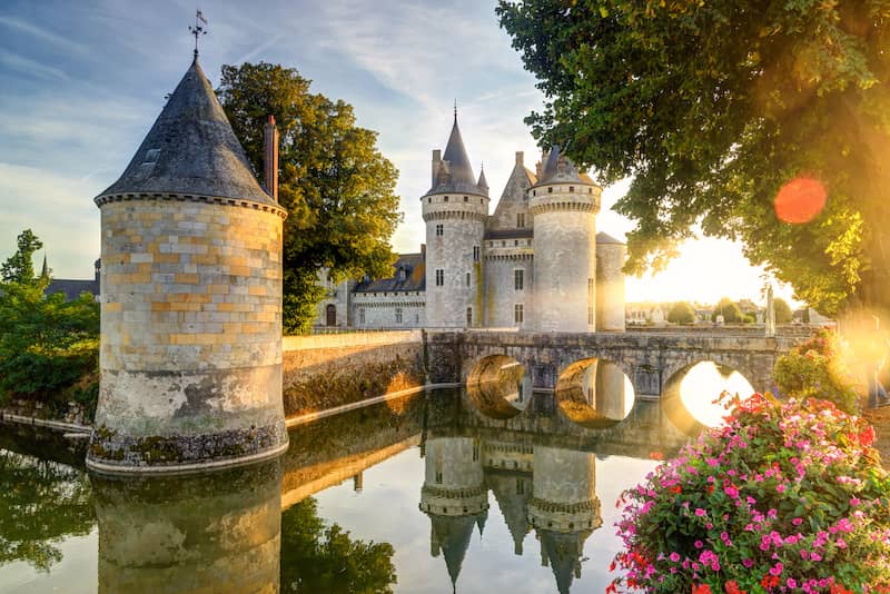 RHB Assets From IGX: Majestic French castle surrounded by lush greenery and a moat.