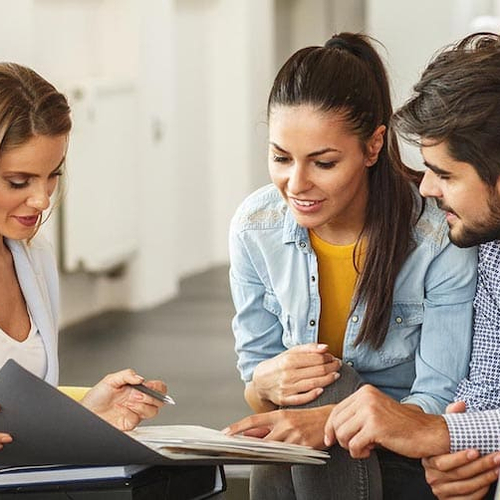 A couple discussing real estate investment or mortgage with an agent.