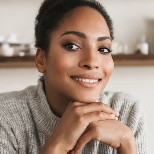 A woman smiling and thinking about something possibly an investment.