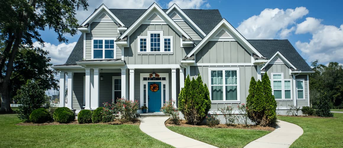 White and grey house with a teal front door.