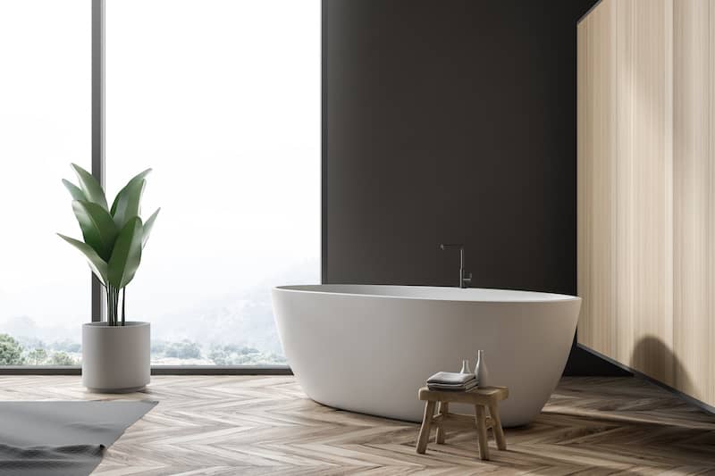 RHB Assets From IGX: Free-standing bathtub in a luxurious bathroom with large windows.