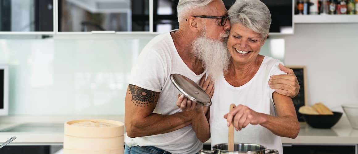 An older couple in kitchen indicating considerations for purchasing a retirement property.