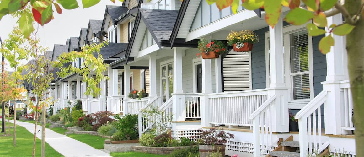 White condos with small porches, depicting a residential complex or condominiums.