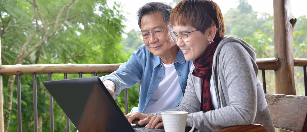 Older couple on laptop together financial planning together.