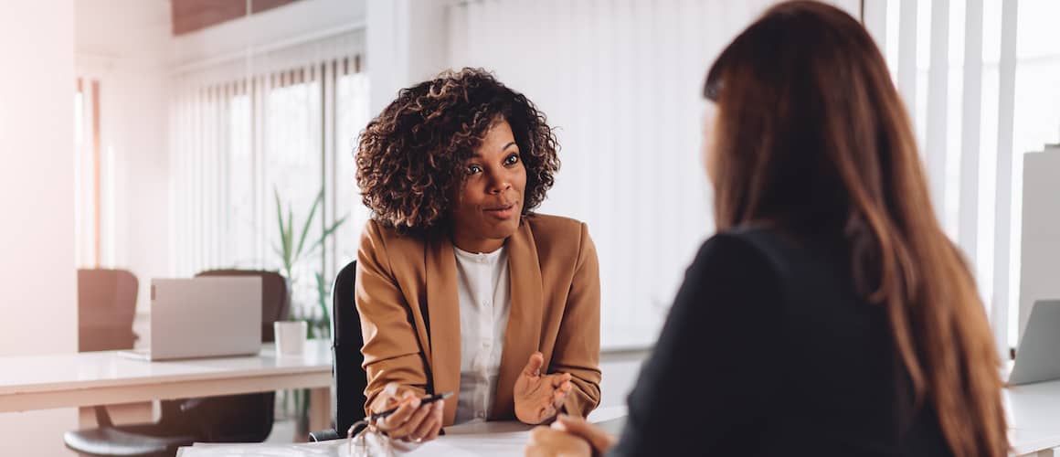 A realtor speaking with a client, potentially discussing property options or real estate transactions.