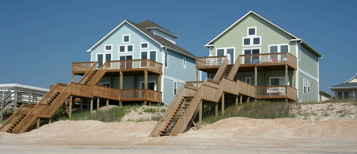 Beachfront home against a blue sky, representing luxurious coastal properties.