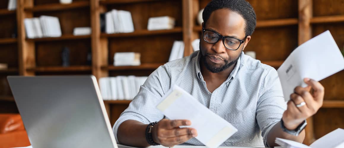 black man looking at bills