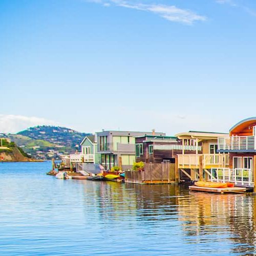 Houseboats floating on water, likely in a residential area.