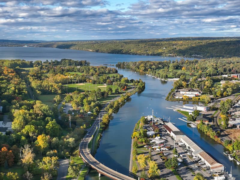 Aerial view of Ithaca with  tons of trees and river flowing into lake.