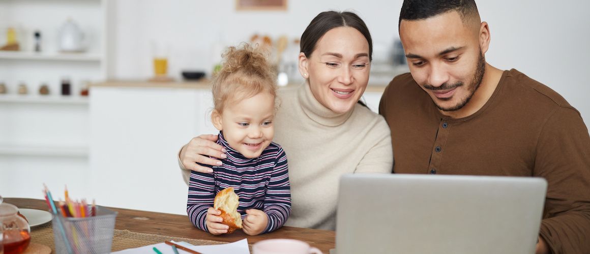 A young family at a kitchen table, possibly discussing household matters or finances.