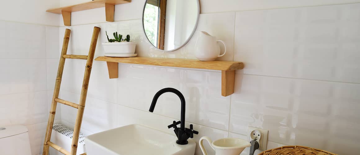 Small white modern bathroom with wooden decorations.