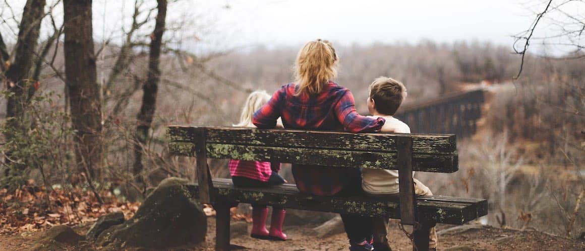 Image of mom on bench with children overlooking view.