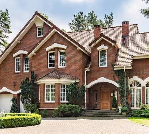 A large brick house surrounded by trees.