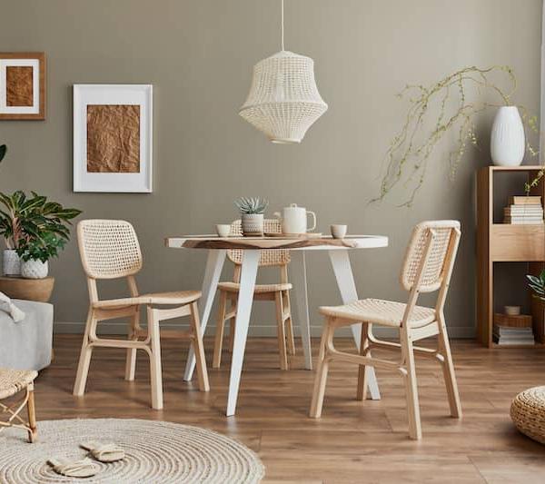 A stylish dining room with family table and rattan chairs.