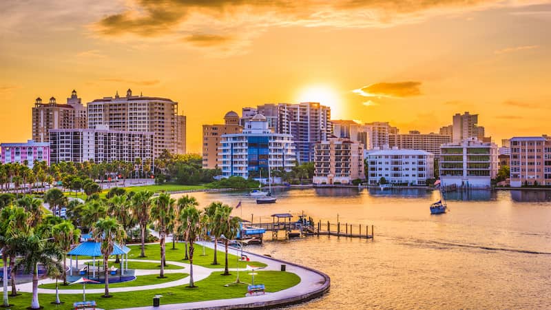 RHB Assets From IGX: Stunning sunset over Sarasota, Florida's waterfront and palm trees.