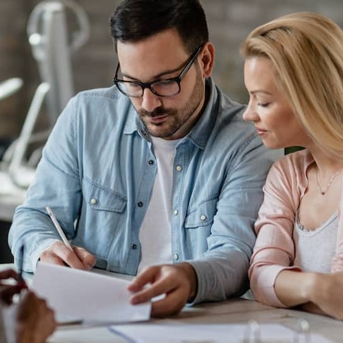 A couple signing documents with an agent.