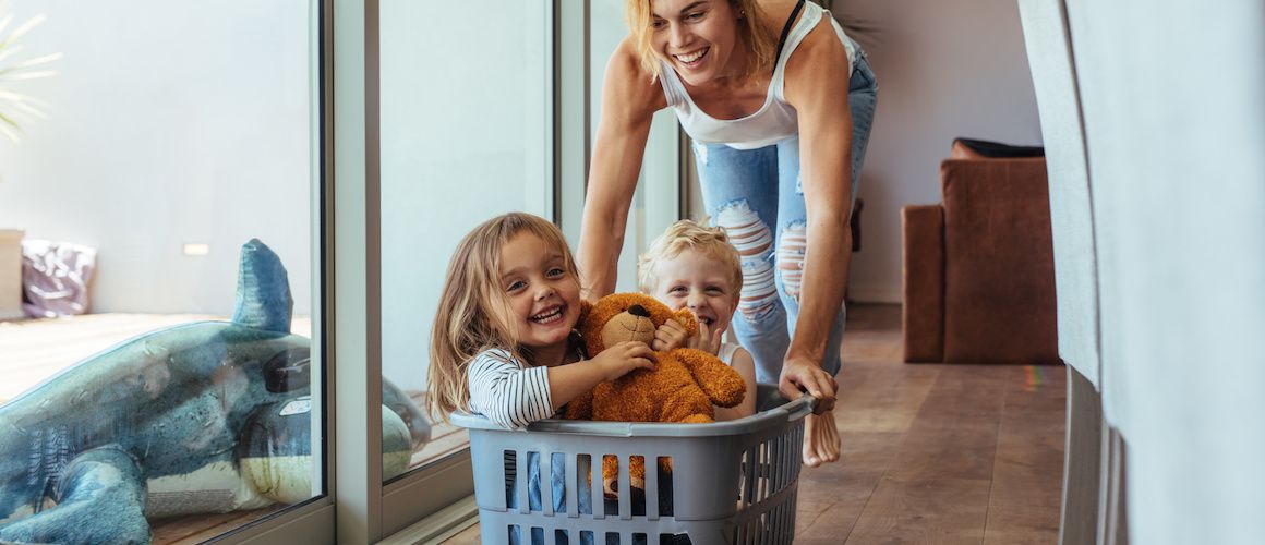 Image of mom pushing children in laundry basket during move-in.