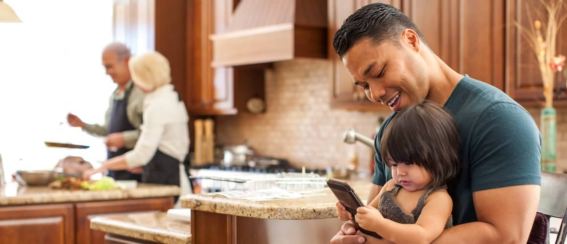 Father and young daughter looking at cell phone. 