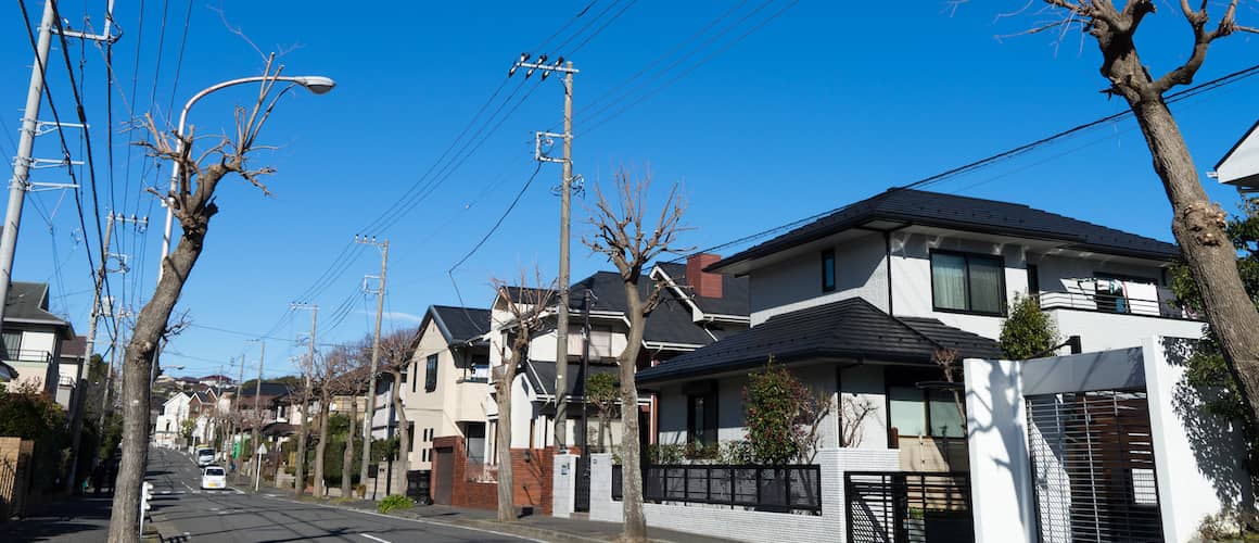 A bustling city street lined with houses and trees, capturing the essence of urban living.