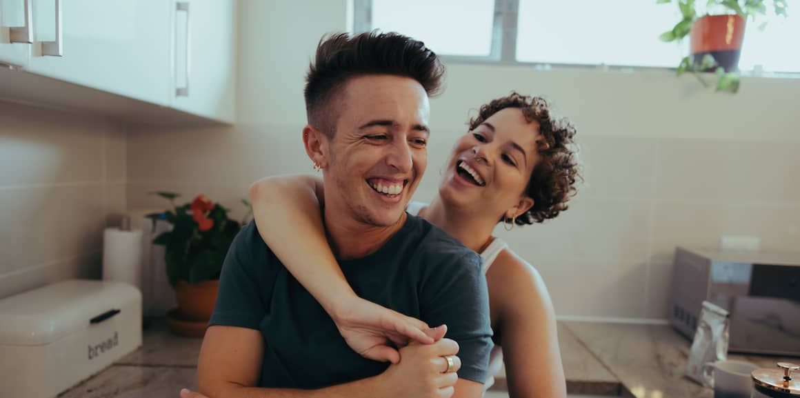 Happy couple standing in a new modern kitchen.