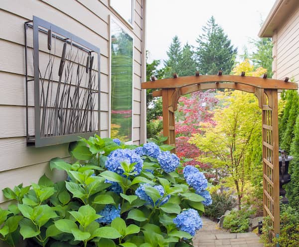 Garden entrance with arch surrounded by flowers and greenery.