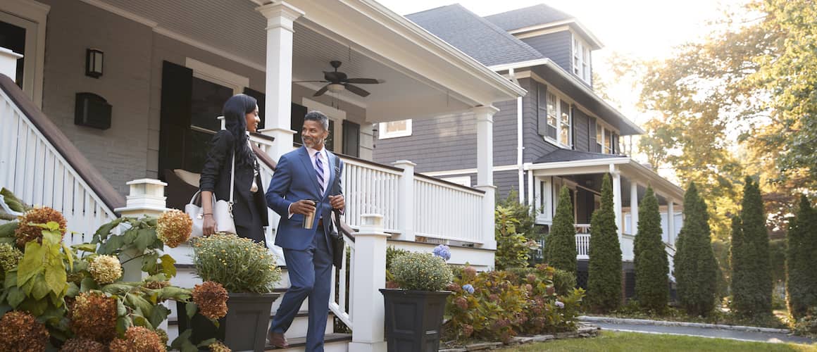 A couple leaving their house probably leaving for their jobs.