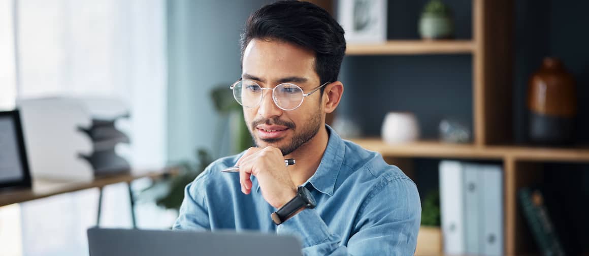 A man working on a computer, potentially doing financial research or managing real estate-related information.