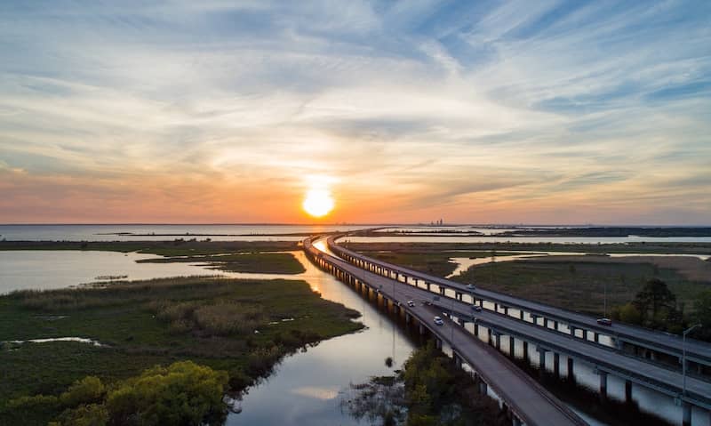 Sunset over Mobile Bay, Alabama causeway over water.