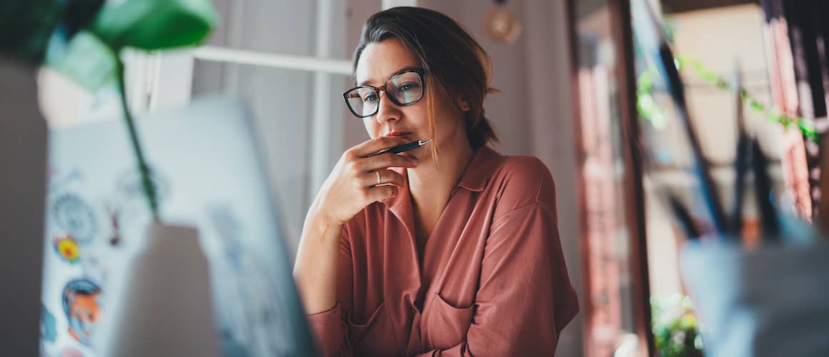 Image showing a young businesswoman contemplating while sitting in front of an open laptop.