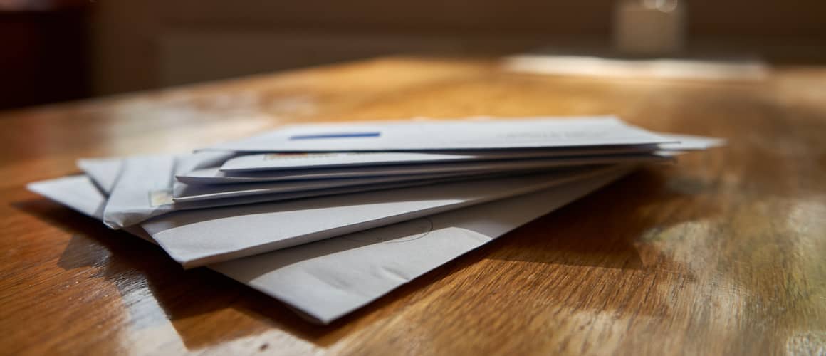 A pile of envelopes stacked on a table.