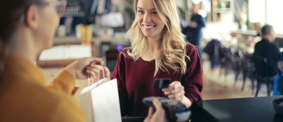 Image of woman paying at store using her credit card.