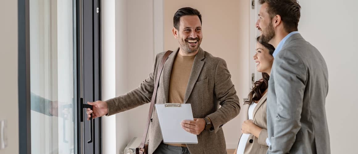 A young couple with a real-estate agent visiting a home for sale 